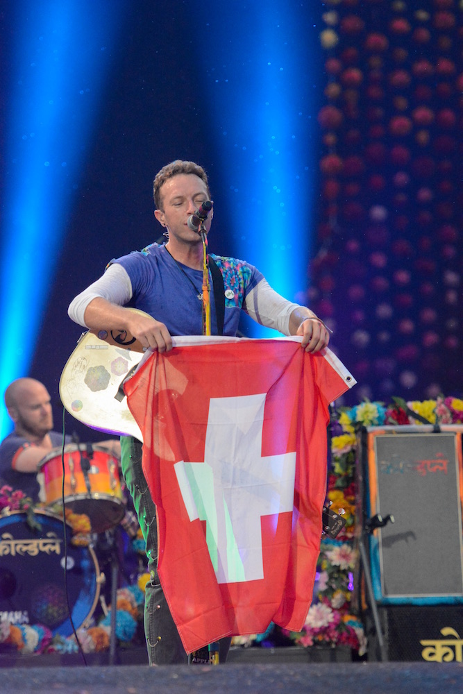 Chris Martin schüttelt die Schweizer Fahne. 